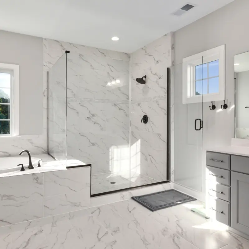 Spotless marble bathroom with a glass shower, soaking tub and clean vanity