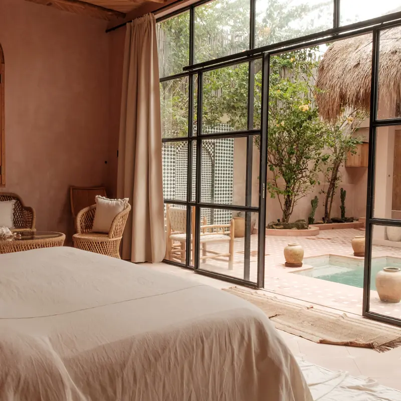 Clean bedroom with fresh linens and natural light from a large window